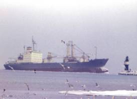 Warnemünde Westmole im Winter 1979 mit einlaufendem Frachtschiff